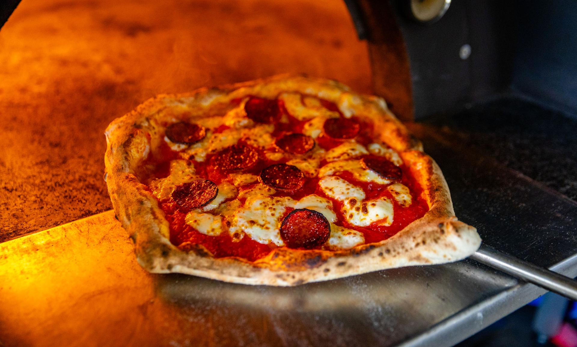 Pizza going into oven